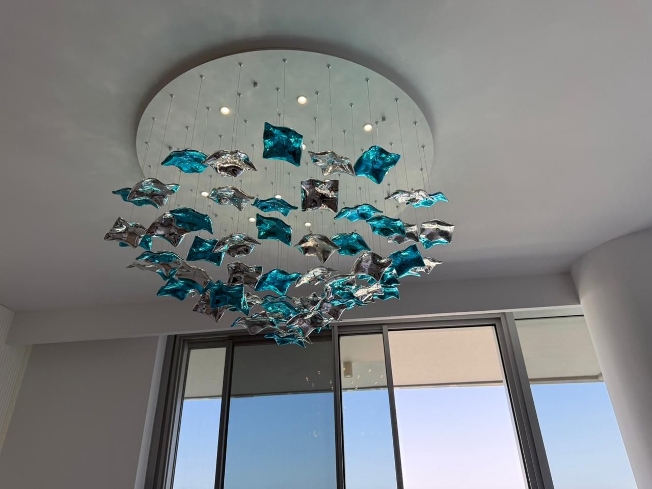 Artistic teal and silver sculptural chandelier installation in Dubai luxury apartment