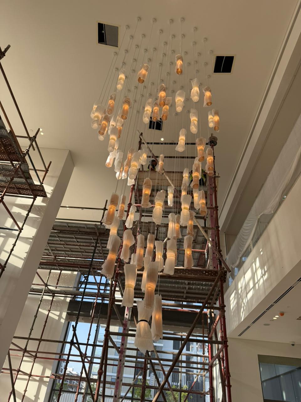 Contemporary chandelier installation with scaffolding in UAE commercial space