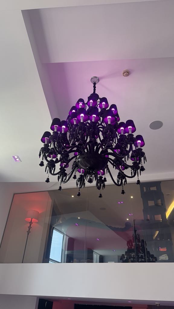 Black chandelier with purple shades installation for distinctive ambiance