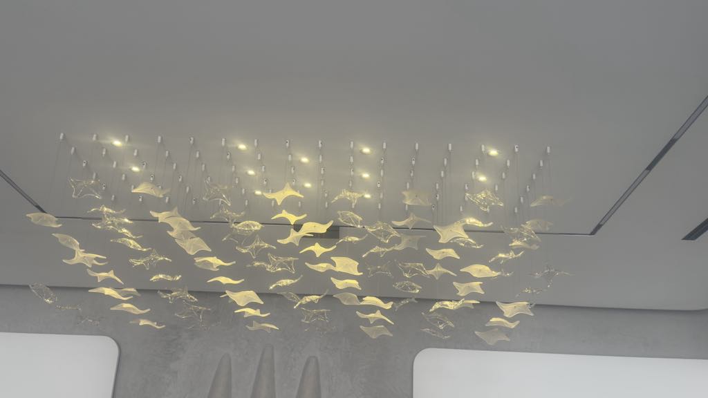 Linear chandelier with suspended glass leaves in modern UAE interior
