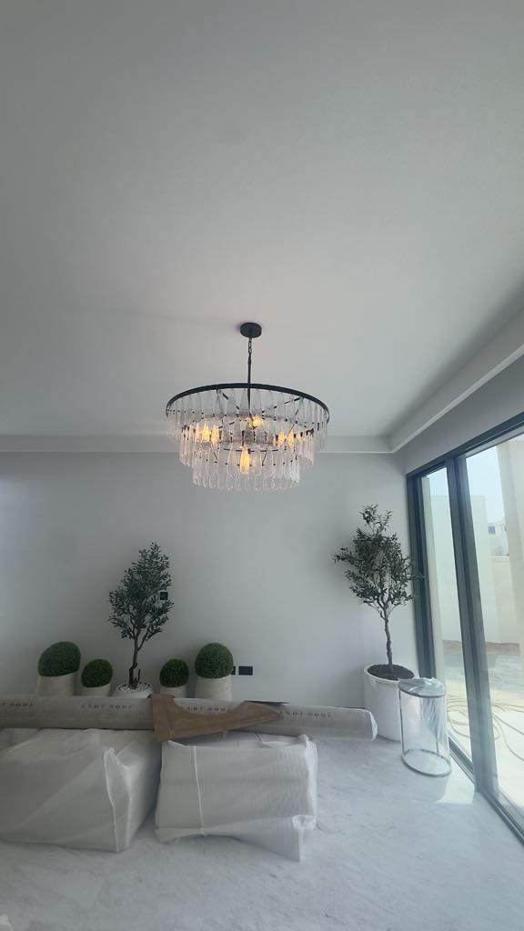 Modern circular chandelier with clear crystal drops installed in UAE home
