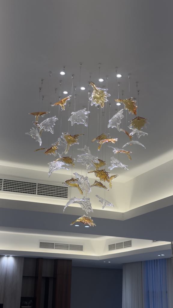 Vertical arrangement of glass elements chandelier installation in UAE